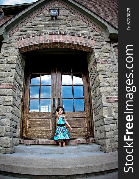 Child standing by an antique door tyring to open it. Child standing by an antique door tyring to open it