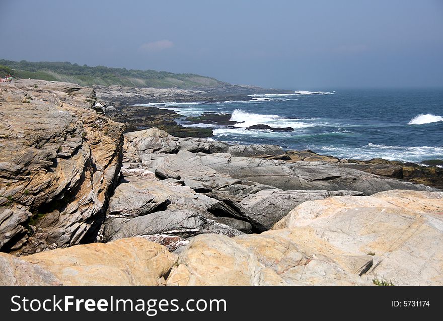 Rocky shore line with waves crashing on the rocks. Rocky shore line with waves crashing on the rocks