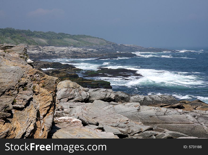 Rocky shore line with waves crashing on the rocks. Rocky shore line with waves crashing on the rocks