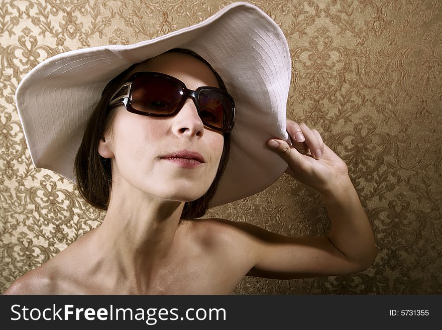 Young Woman with Sunglasses and a Floppy White Hat