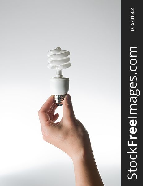 Hand holding an energy efficient light bulb on a white background