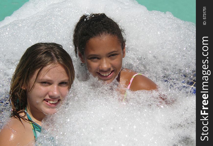 A picture of two tween girls in bubbles in a jacuzzi. A picture of two tween girls in bubbles in a jacuzzi.