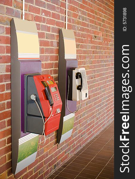 Traditional coin telephone set hanging on red brick wall. Traditional coin telephone set hanging on red brick wall