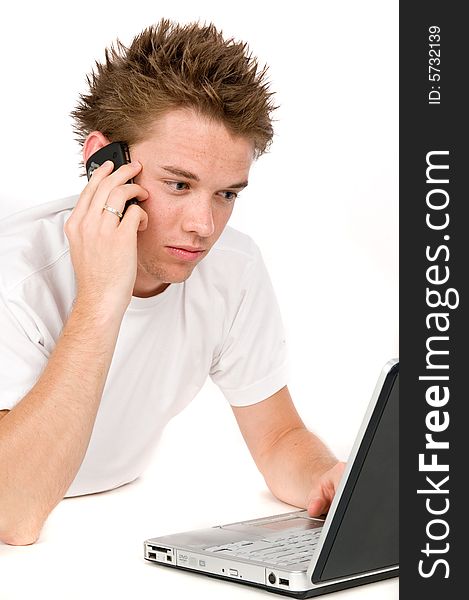 A young man multitasking on the phone and computer