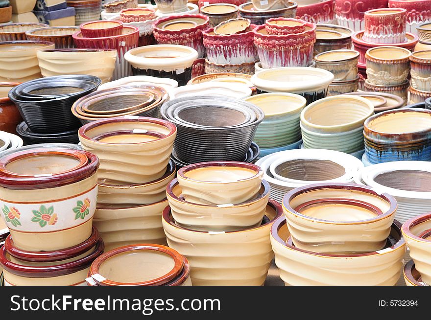 The ceramic plant pots of various shapes and colors in a market. The ceramic plant pots of various shapes and colors in a market.