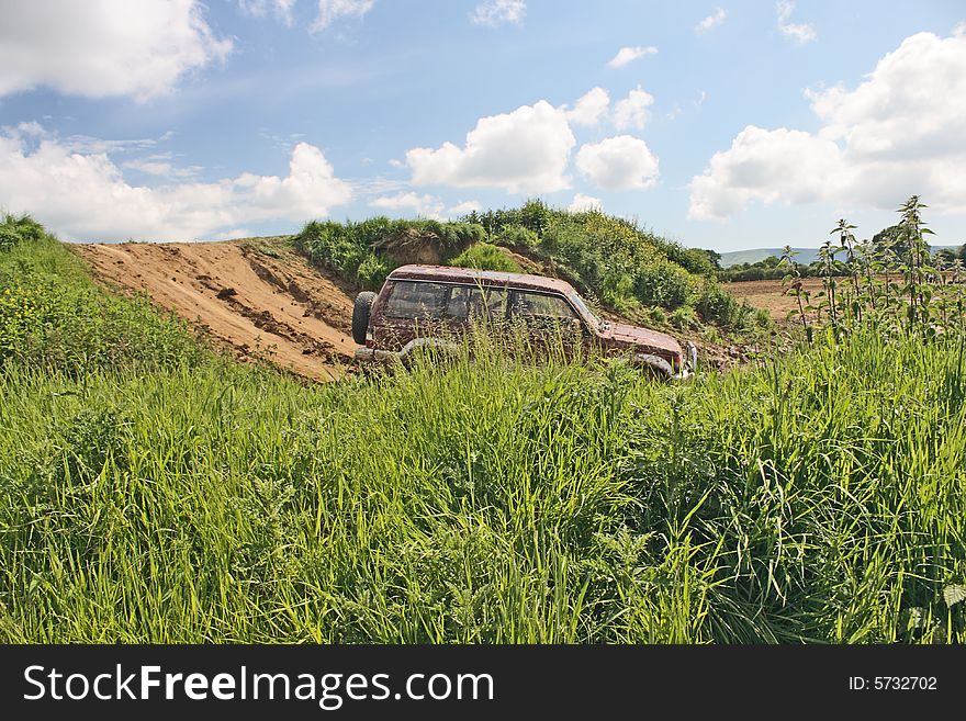 A 4x4 vehicle driving through rough hilly ground. A 4x4 vehicle driving through rough hilly ground