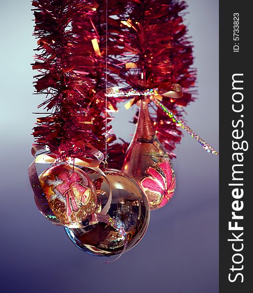 Christmas ornaments hanging at red  strings, purple background