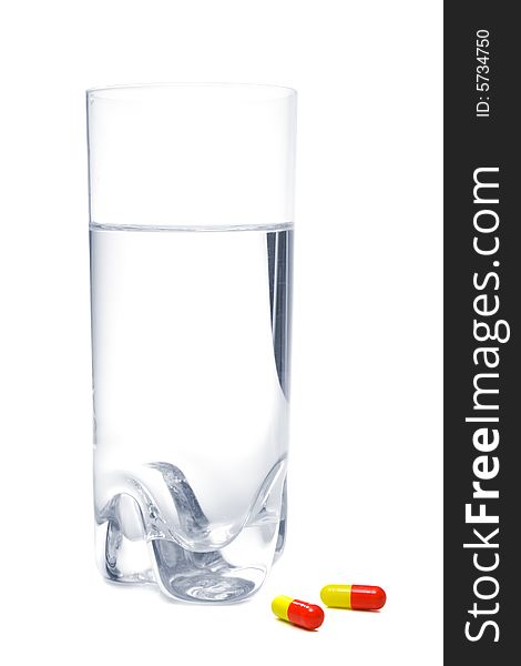 Glass with water and pills, isolated, on white background