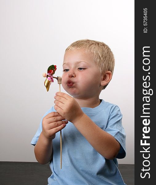 Toddler playing with a wind toy made of bright colors. Toddler playing with a wind toy made of bright colors