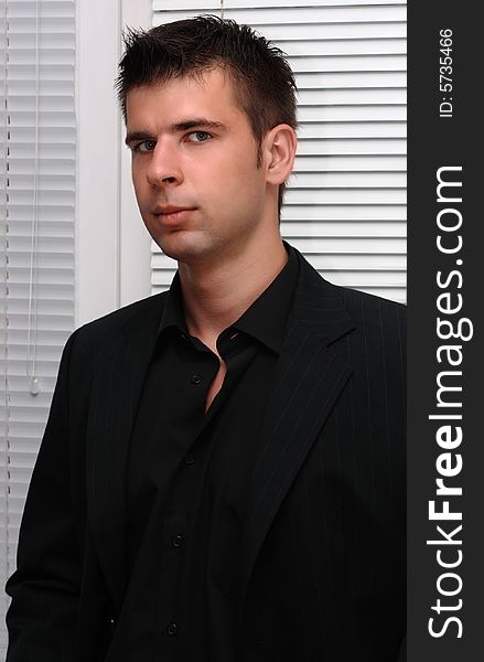 Portrait of a young businessman dressed in black suit