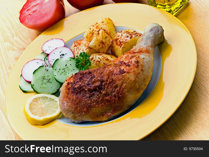 Fried chicken with fried potatoes, and cucumber,tomato,radish.