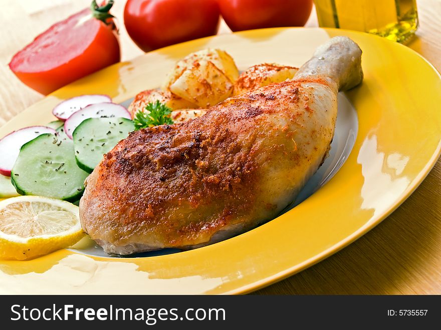 Fried chicken with fried potatoes, and cucumber,tomato,radish.