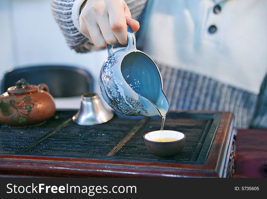 Man pouring green tea to traditional japanese cups