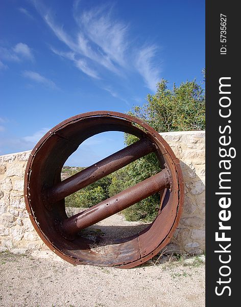 Juxtaposition of a modern stone wall built around a rusty old cylindrical mining object, in the Innes National Park; Yorke Peninsula; South Australia. Juxtaposition of a modern stone wall built around a rusty old cylindrical mining object, in the Innes National Park; Yorke Peninsula; South Australia.