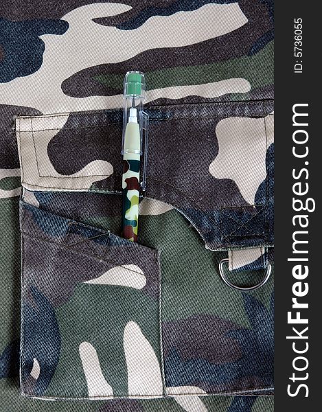 A military styled garment with a camouflaged pencil on top of it. A military styled garment with a camouflaged pencil on top of it.