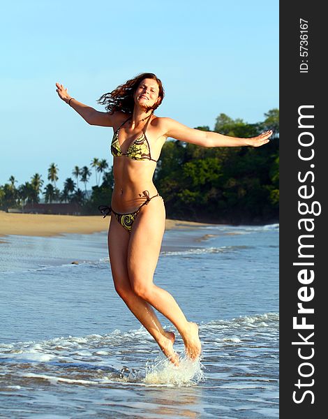 Young woman is jumping happily on the beach. Ideal shot for vacation or summer. Young woman is jumping happily on the beach. Ideal shot for vacation or summer.