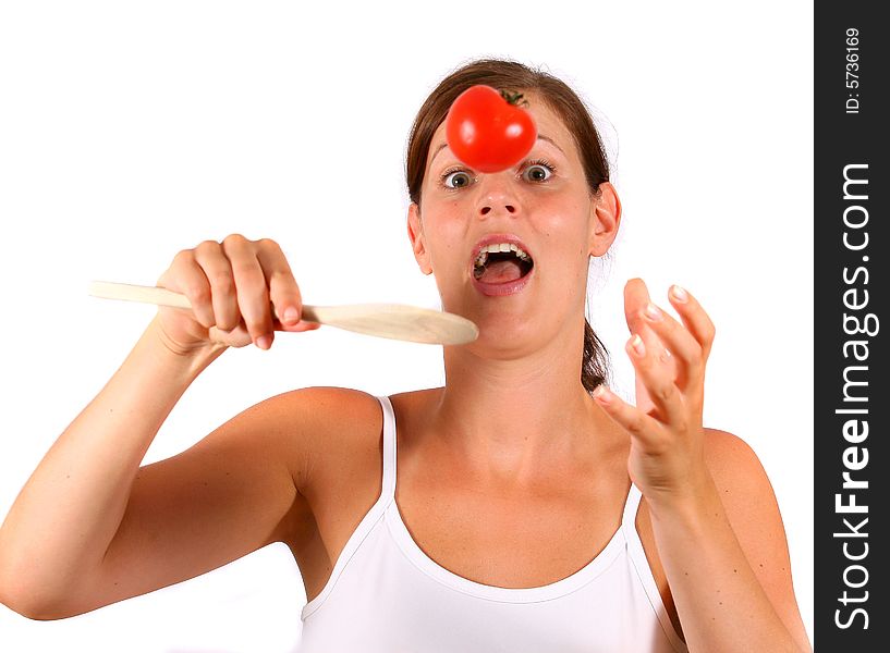 A young happy woman with a tomato and a spoon. Can be used as a cooking / diet shot. A young happy woman with a tomato and a spoon. Can be used as a cooking / diet shot.