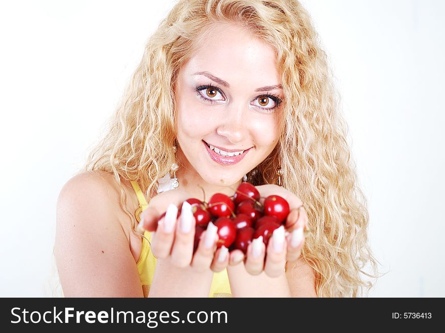 Beauty young woman with opened eyes and red cherry in mouth