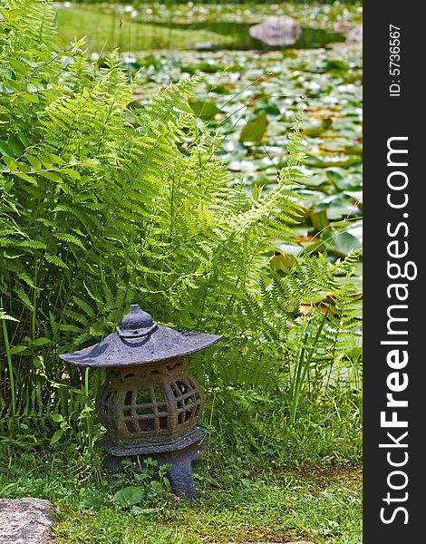 Japanese lantern at lily pond in stroll garden.