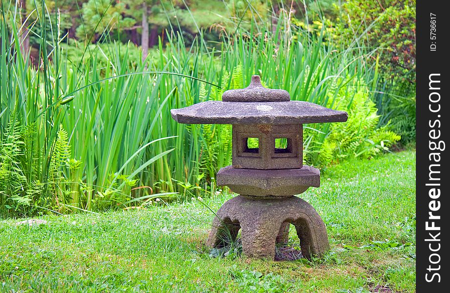 Japanese lantern in a stroll garden with reeds.