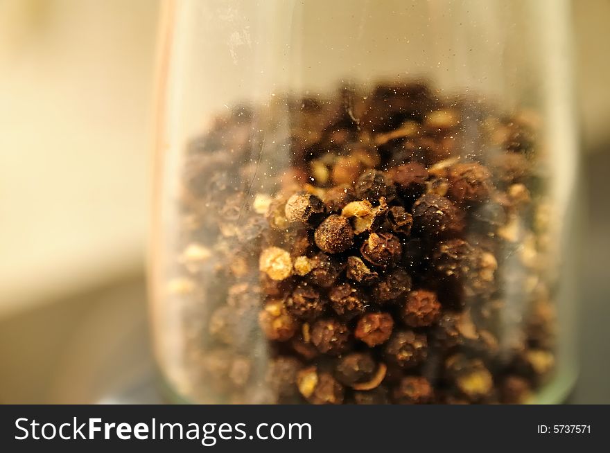 Black pepper grains in a pepperpot. Close shot