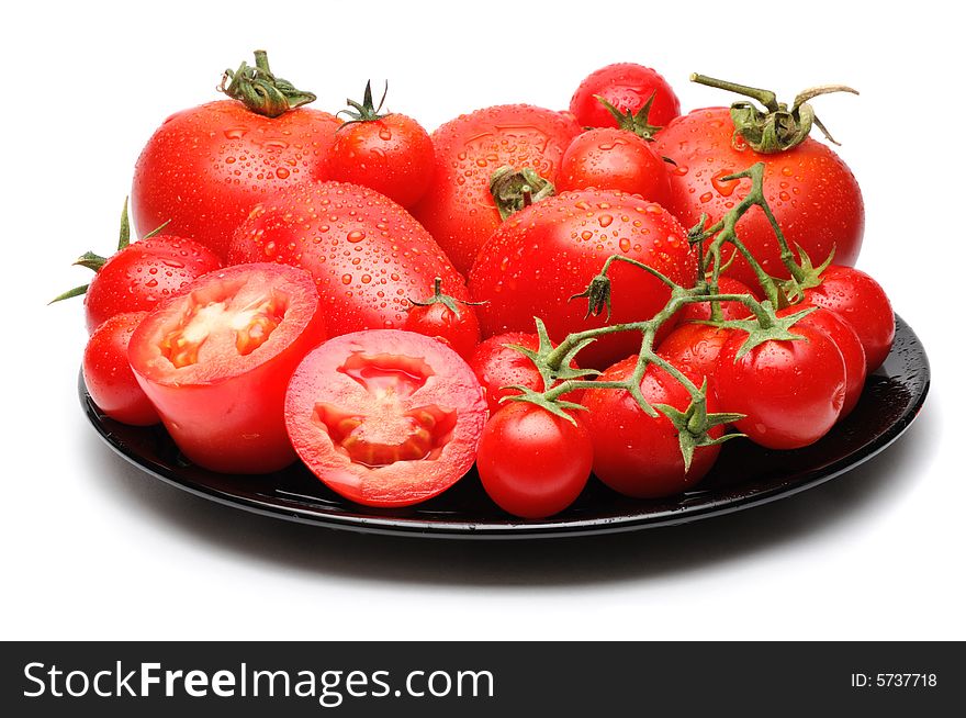Fresh tomatoes of different variety on black dish isolated on white. Fresh tomatoes of different variety on black dish isolated on white