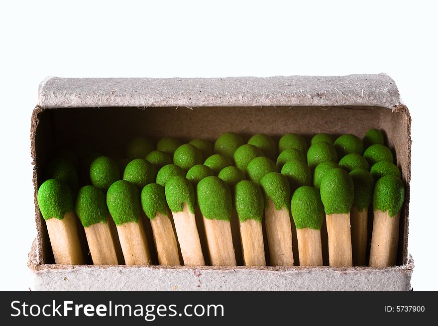 Old matchbox containing many green matches