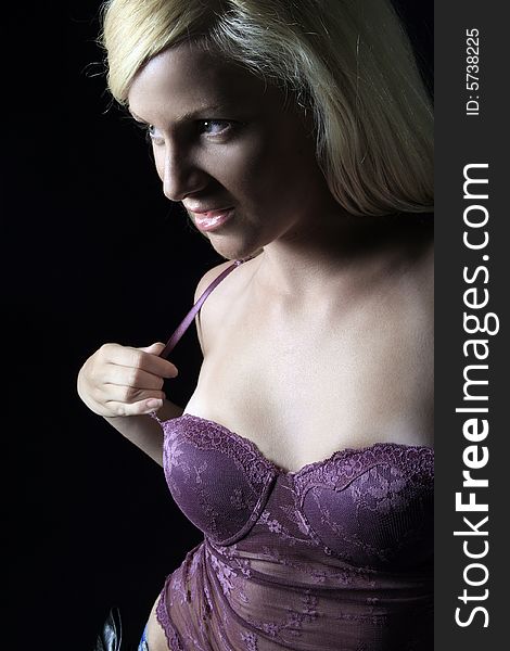 Pretty blond woman in purple corset on black. Pretty blond woman in purple corset on black