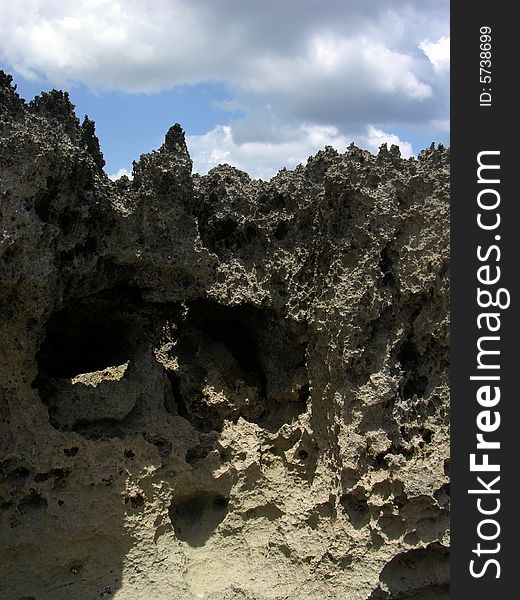 The rich rock texture with clouds above it on private resort beach in Nassau town, The Bahamas. The rich rock texture with clouds above it on private resort beach in Nassau town, The Bahamas.