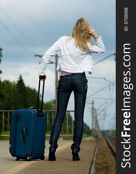 Beautiful young lady with luggage waiting a train. Beautiful young lady with luggage waiting a train