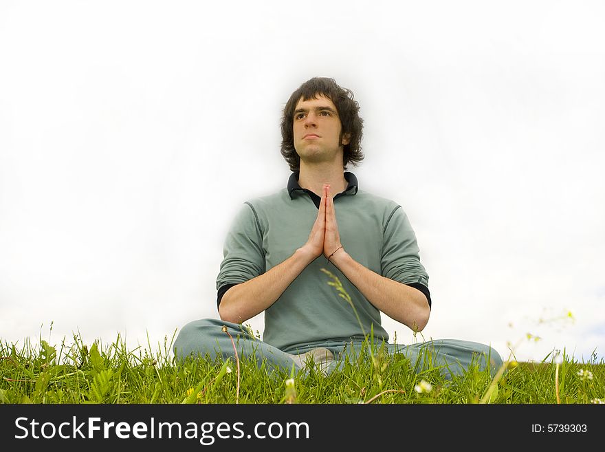 A man sitting in the lotus posture on the grass