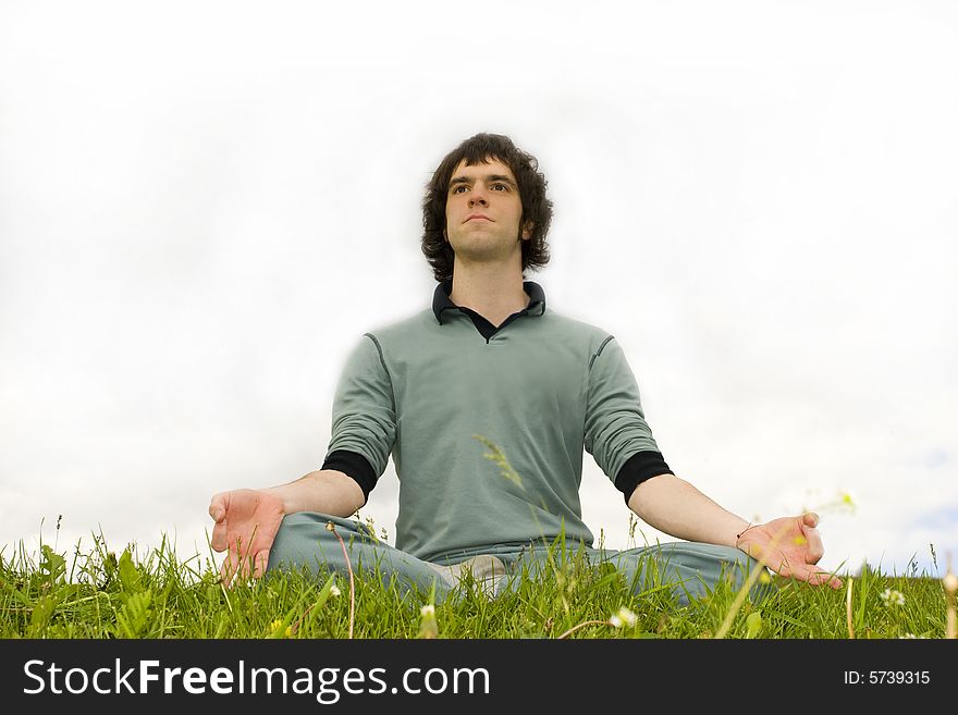Man sitting in the lotus posture on the grass