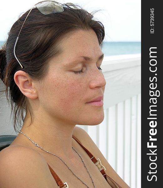 The portrait of the girl with closed eyes on Sandyport beach in Nassau town, The Bahamas.