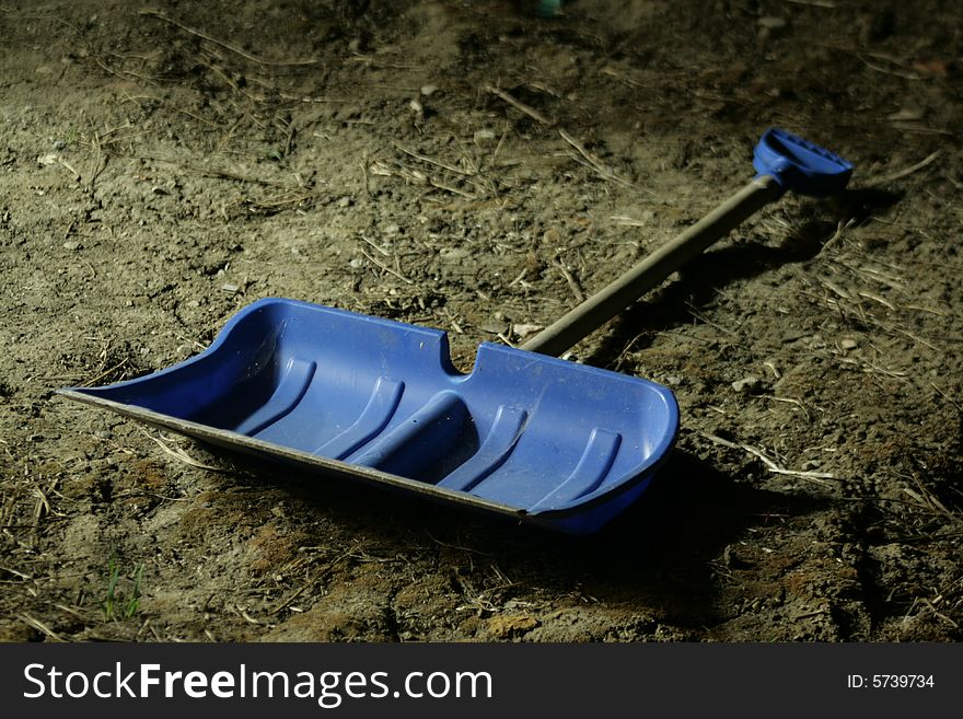 Blue plastic shovel whit wooden barrel.