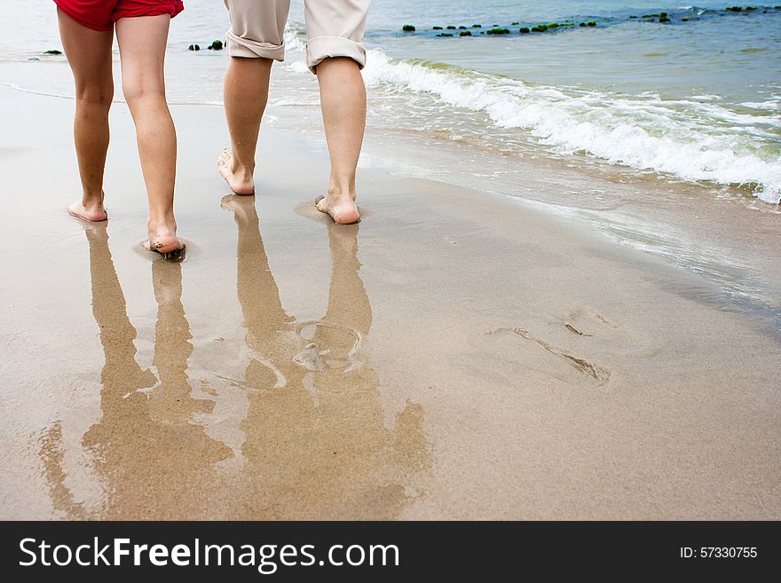 Mother and daughter are on the beach on summer. feet close-up