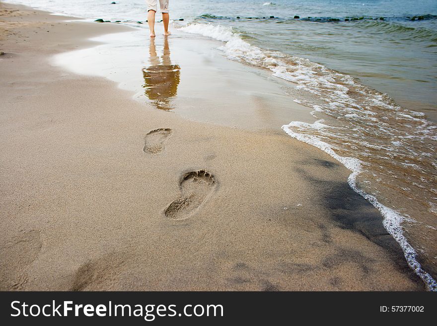 Woman's footprints on the seashore on summer day closeup. Woman's footprints on the seashore on summer day closeup