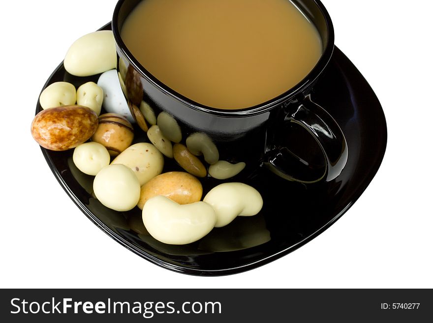 Close-up black coffee cup with milk and candies, isolated on white