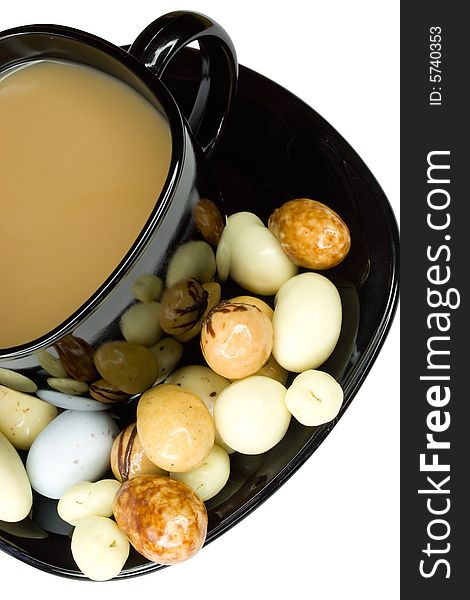 Close-up black cup of coffee with milk and candies, isolated on white