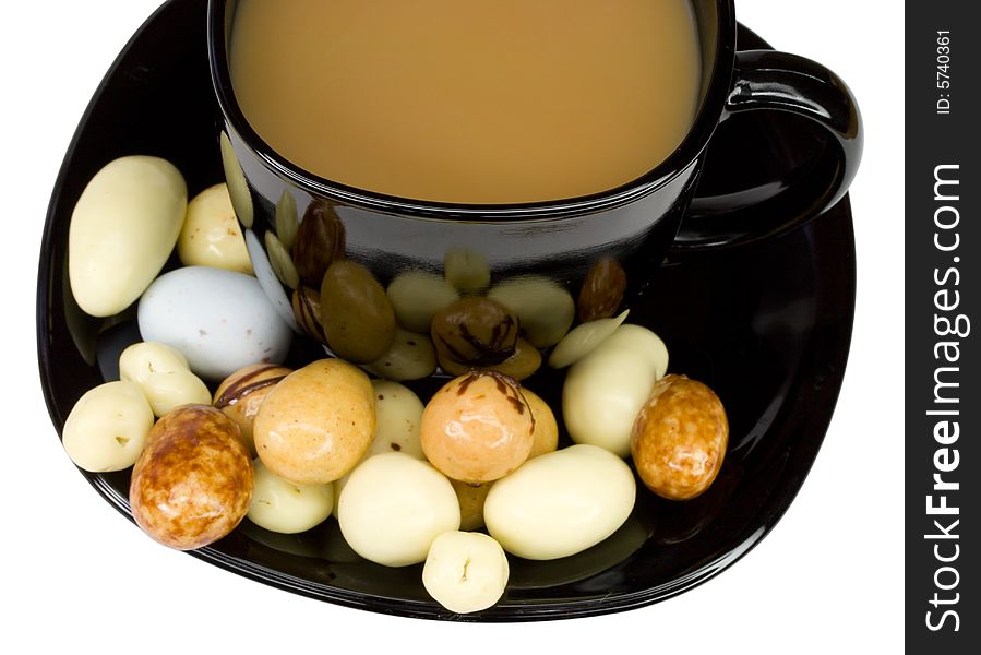 Close-up black coffee cup with milk and candies, isolated on white