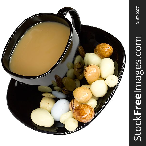 Close-up cup of coffee with milk and candies, isolated on white