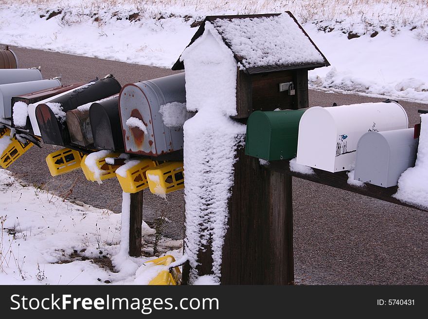 A row of rural mailboxes covered in snow. A row of rural mailboxes covered in snow