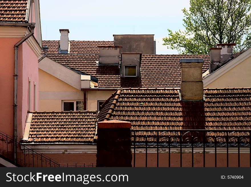 Tile roofs of the old houses with chimneies
