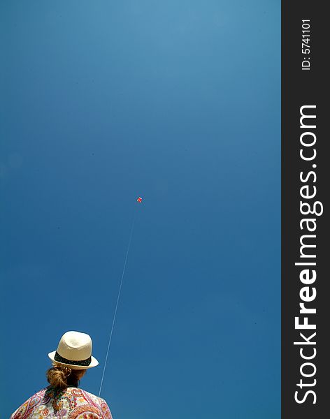 Woman flying distant kite via string. Woman flying distant kite via string