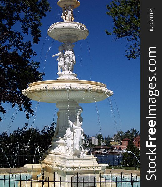 A beautiful fountain stands in front of clear blue sky in summer. A beautiful fountain stands in front of clear blue sky in summer