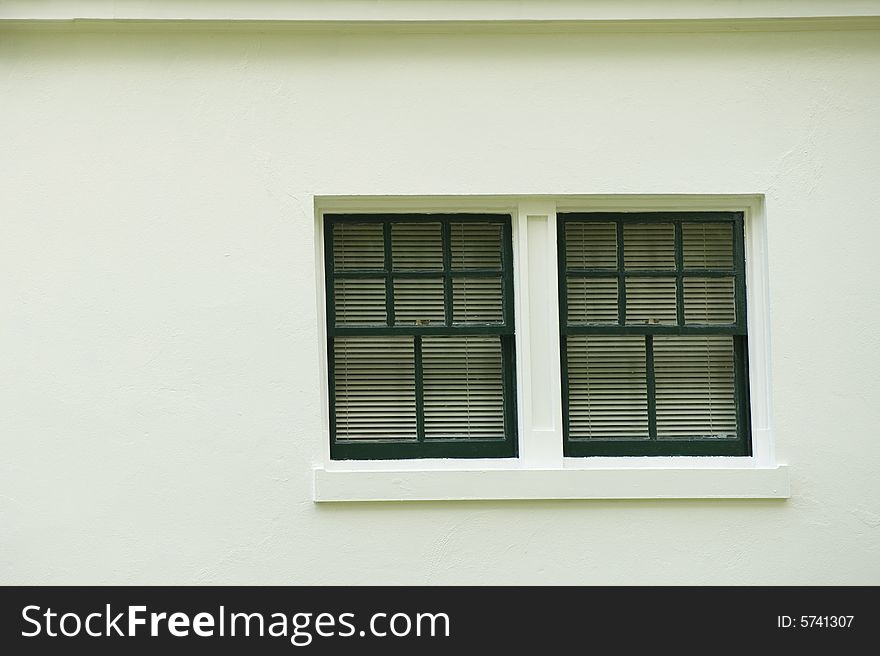 Close up of a window on the side of a white stucco building. Close up of a window on the side of a white stucco building.