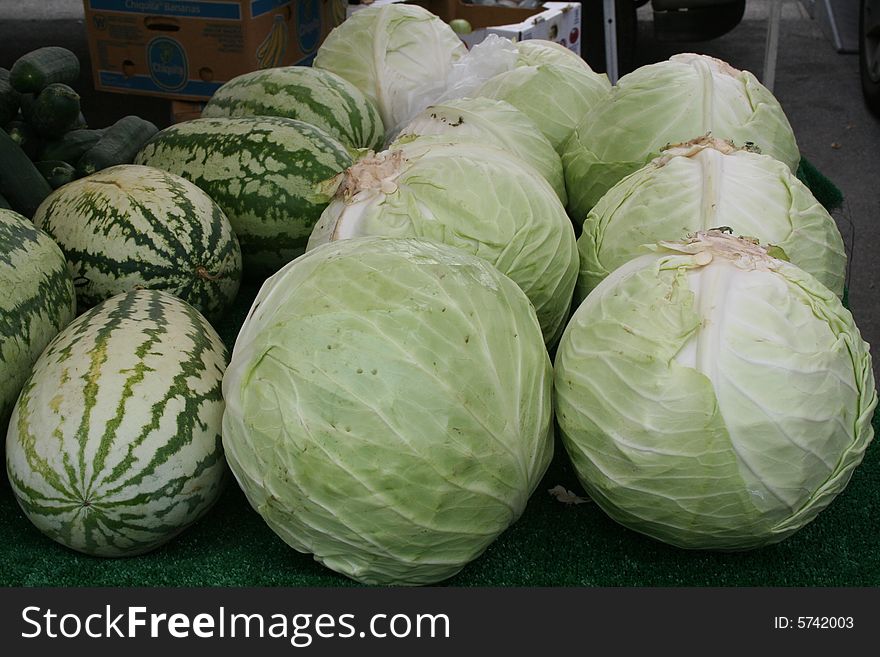 Cabbage and melons at a farmer's market.