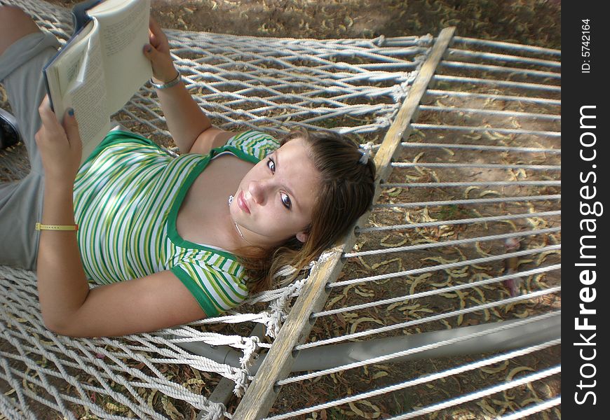 A picture of a teen girl reading in a hammock. A picture of a teen girl reading in a hammock.