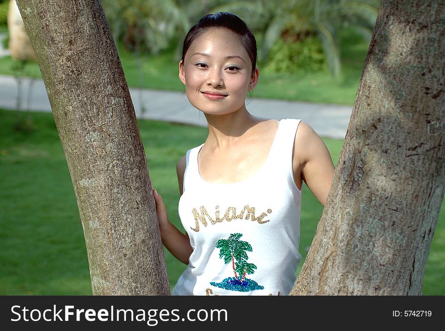 Chinese girl standing between two tree branches. Chinese girl standing between two tree branches.