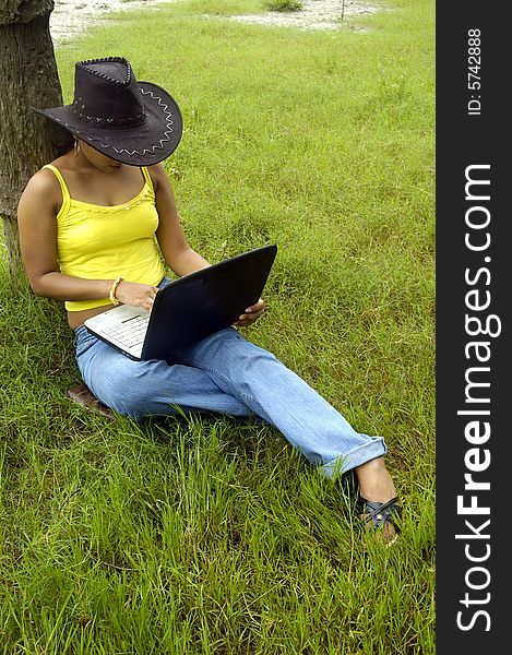 A Indian woman with a laptop in a park. A Indian woman with a laptop in a park.