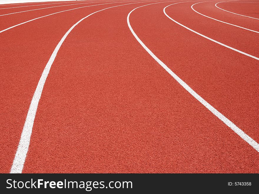 Curved red running tracks in outdoor arena